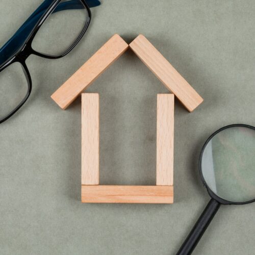 real-estate-concept-with-house-made-wooden-blocks-glasses-magnifying-glass-grey-background-close-up_176474-7849-500x500 Les bonnes pratiques pour limiter les risques d'incendie : vérification obligatoire